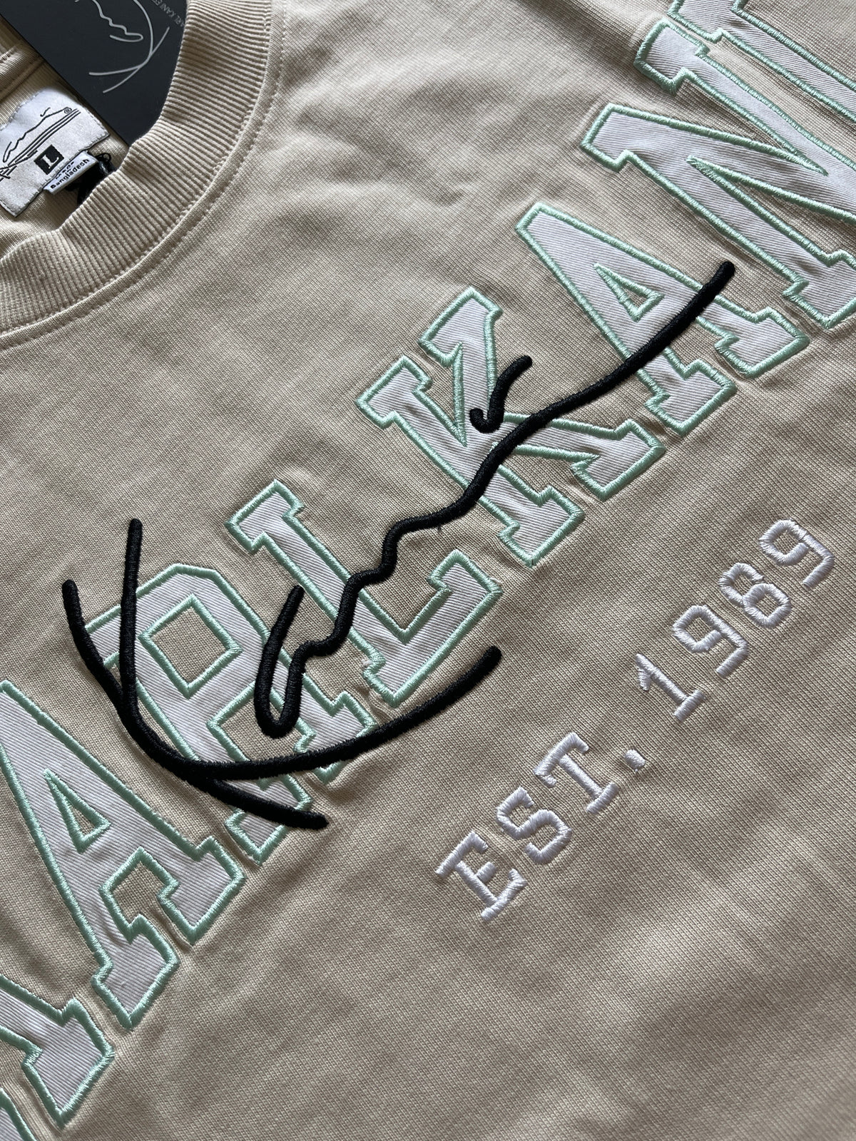 Karl Kani Tshirt in creme mit großem Schriftzug in weiß/türkis/schwarz, Größe wählbar