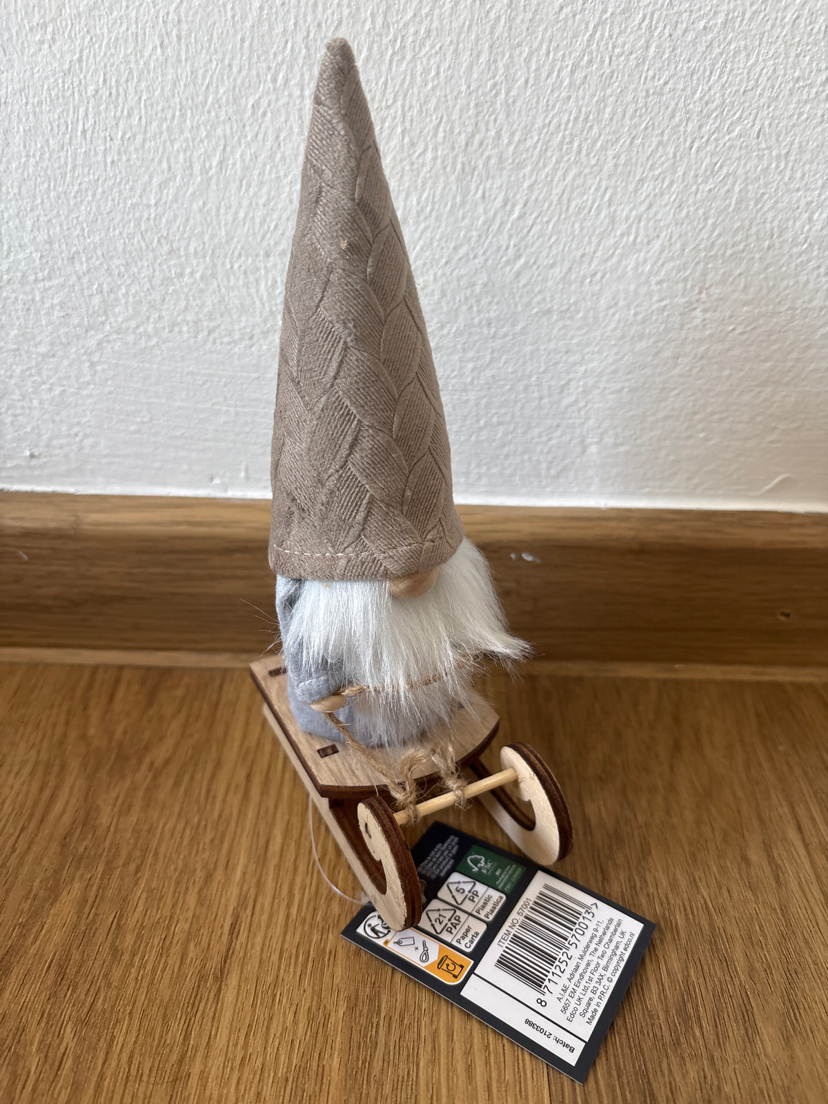Deko kleiner Weihnachtszwerg auf einem Schlitten, beige Mütze