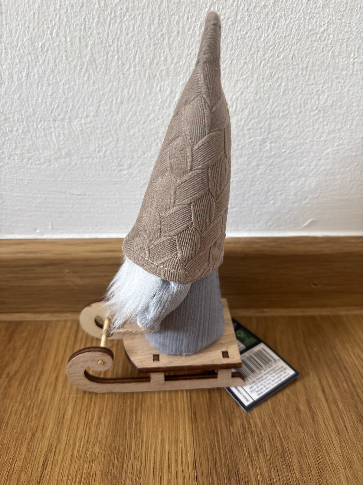 Deko kleiner Weihnachtszwerg auf einem Schlitten, beige Mütze
