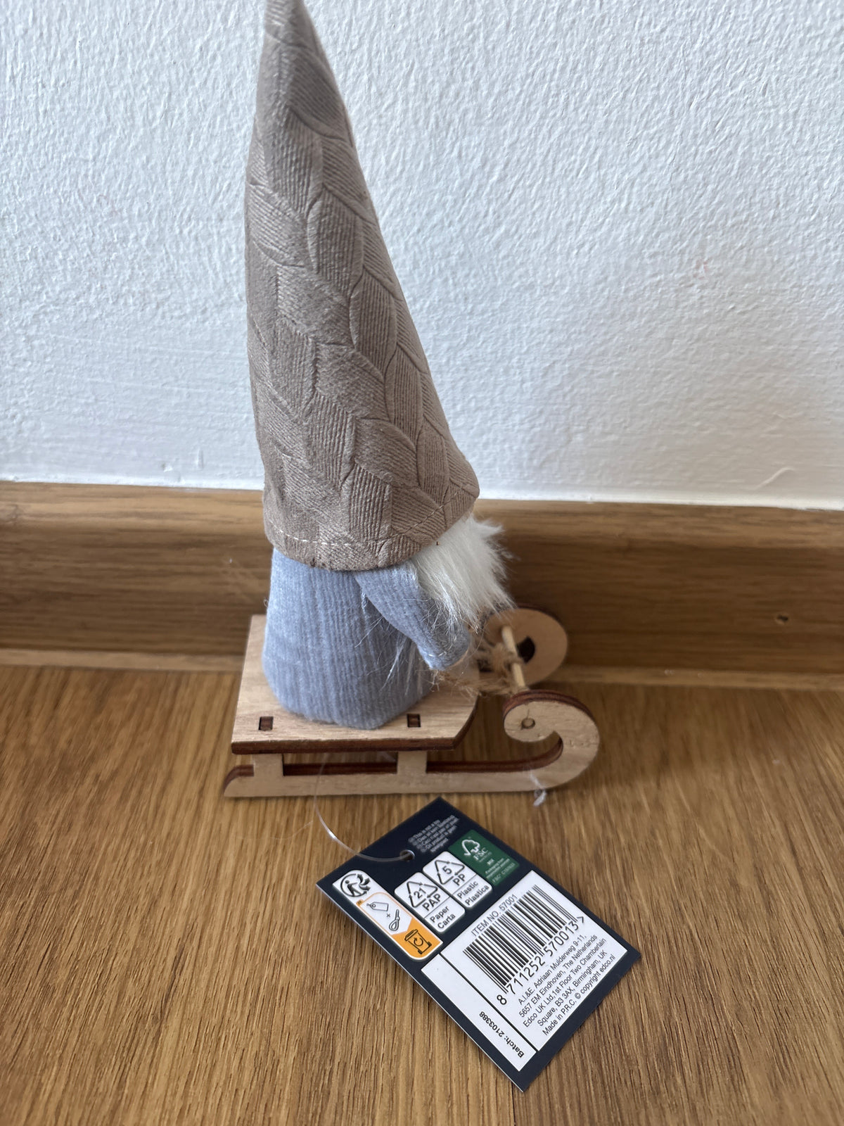 Deko kleiner Weihnachtszwerg auf einem Schlitten, beige Mütze